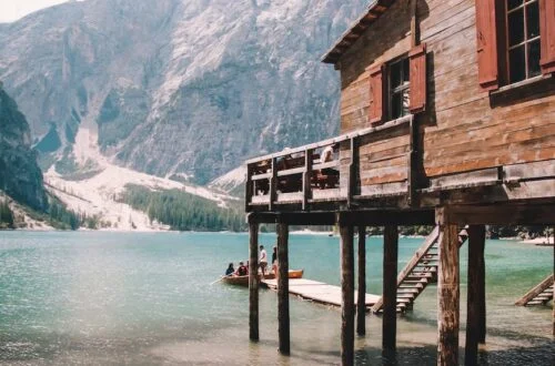 wooden house on pillars at mountain lake