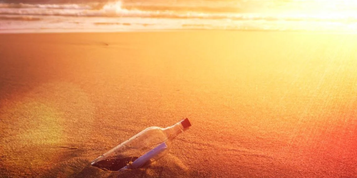 clear glass bottle on brown sand