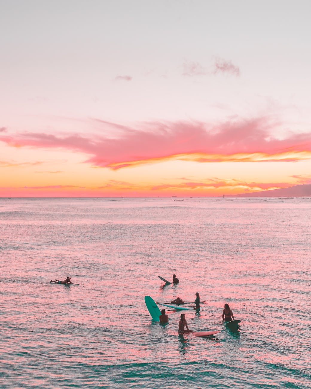 people sitting on surfboards while in body of water during a surfside prom party - houston prom party ideas